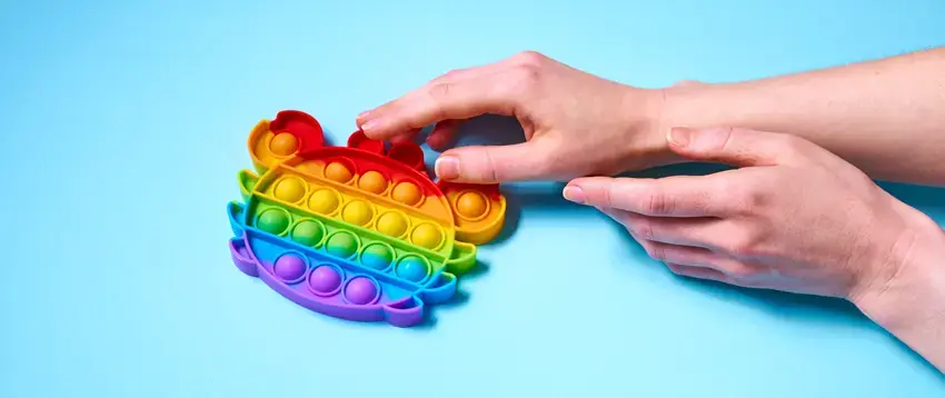 Hand reaching out to a crab-shaped toy